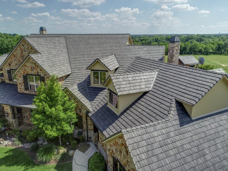 brown davinci slate composite roof surrounded by trees and blue sky