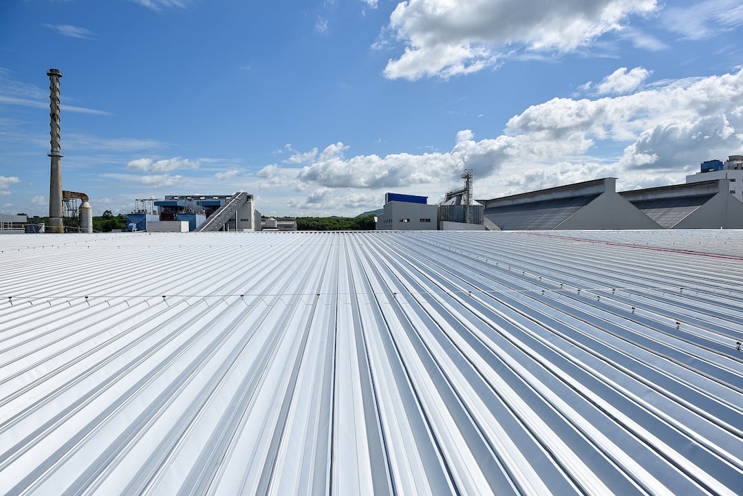 corrugated silver metal roof of commercial building with blue sky
