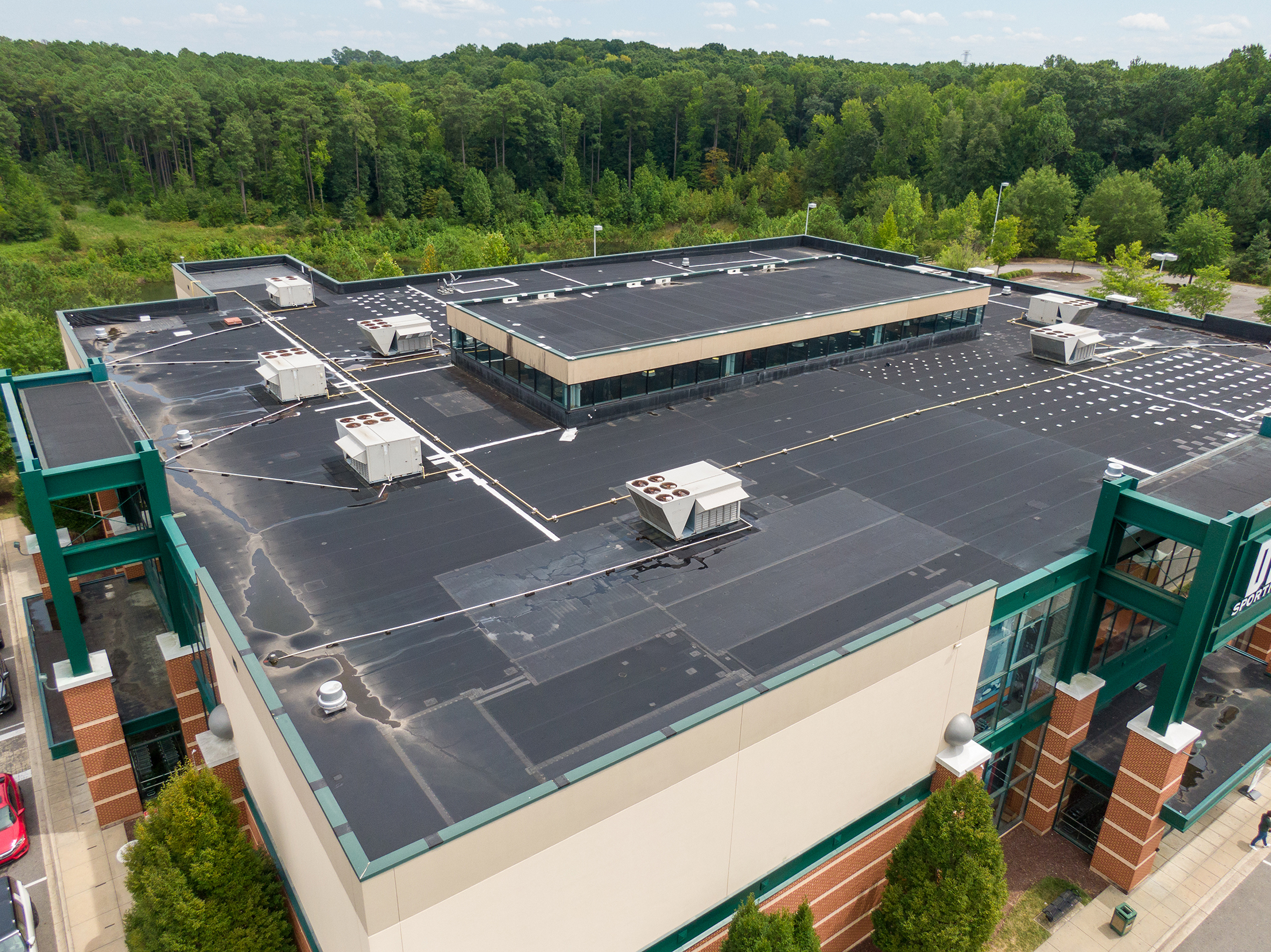 a building with many air conditioning units on the roof and a flat roof