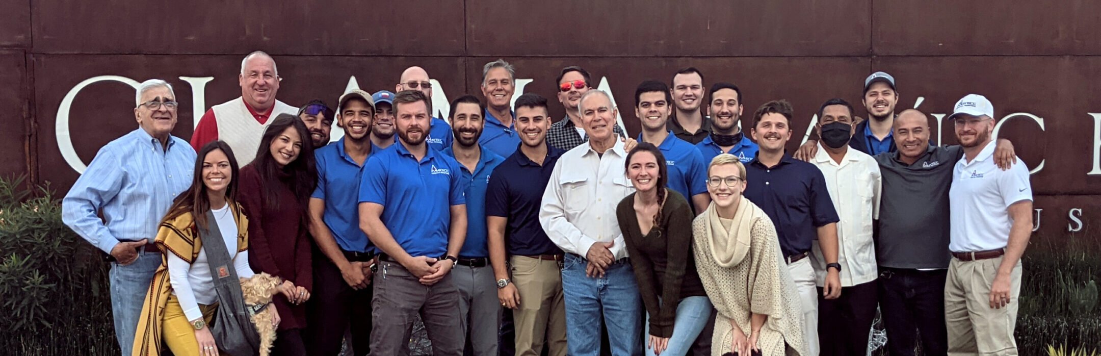 amstill roofing team smiling outside houston office building
