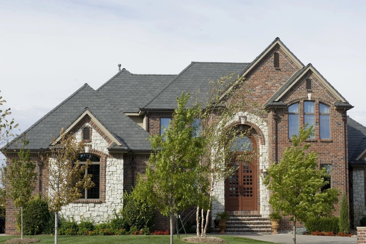 trees in front of large home with new composite roof