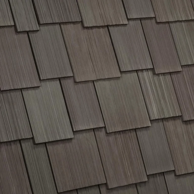 A roof with overlapping wooden shingles, showing a uniform, textured pattern in shades of brown and gray. The shingles are rectangular and arranged in a staggered formation. The image highlights the variation in color and grain of the wood.