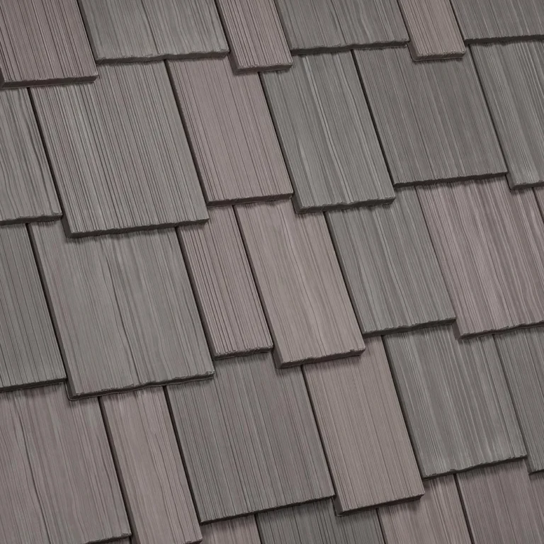 A close-up view of a roof covered with overlapping, rectangular shingles in varying shades of gray. The textured surface of each shingle provides a distinct pattern, creating a visually appealing and uniform appearance.