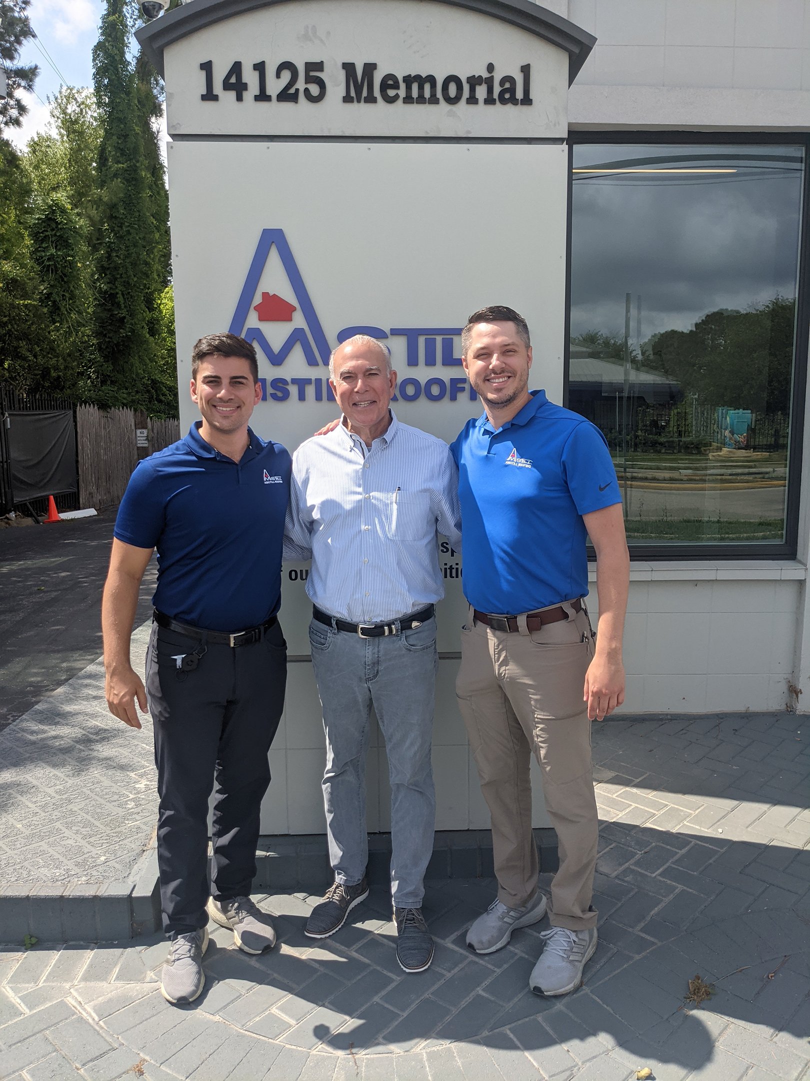 three amstill roofing employees in front of amstill sign and building