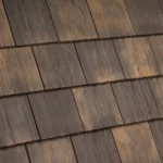 Close-up view of a wooden shingle roof displaying a regular pattern of overlapping, rectangular wooden tiles. The shingles have a natural, weathered brown appearance with subtle texture details, highlighting the grain and variations in color.